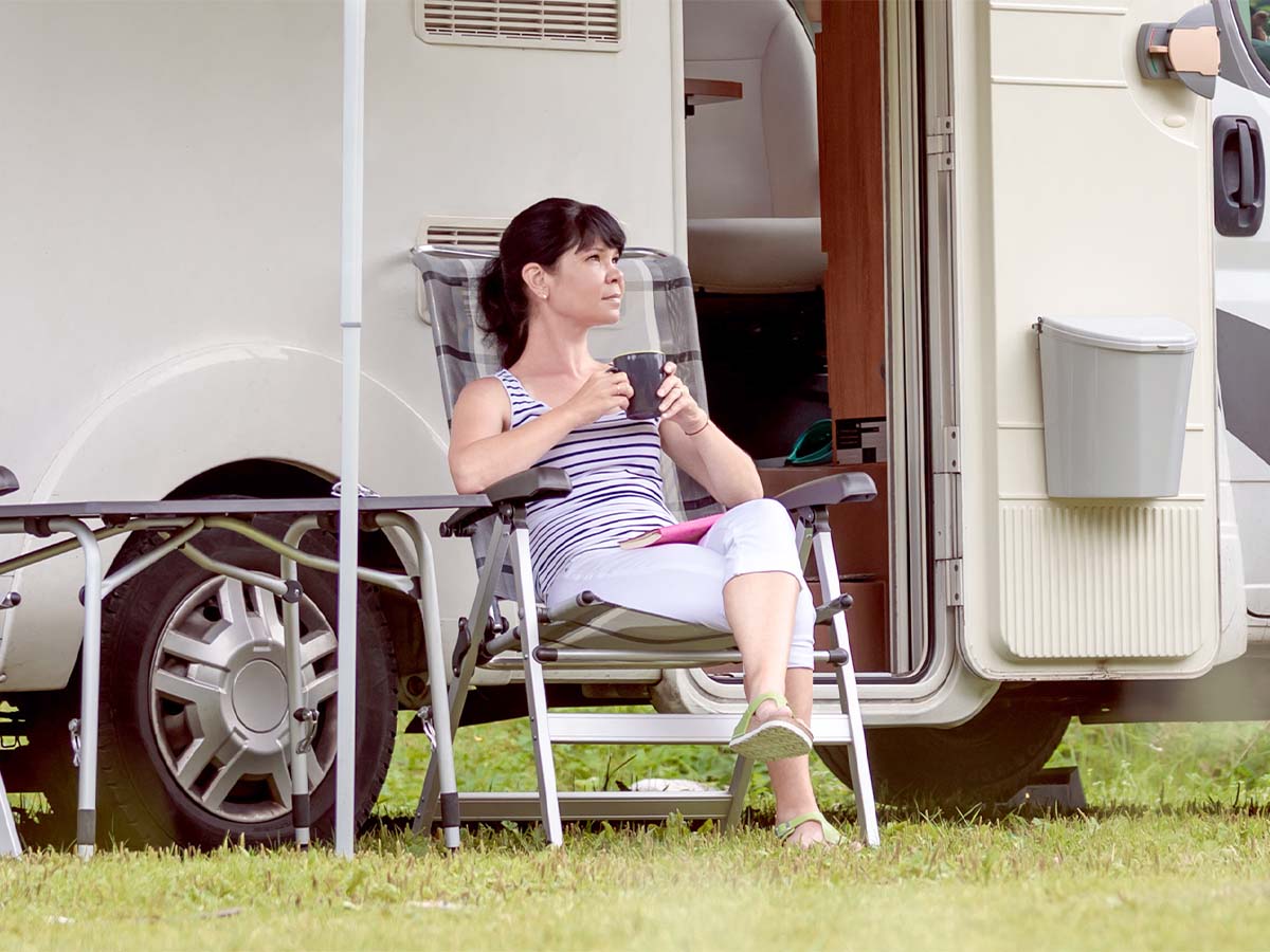 Woman drinking coffee outside of camper